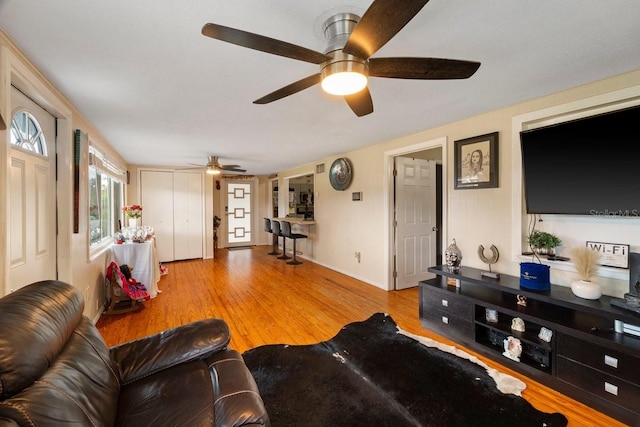 living room with light wood-type flooring and ceiling fan