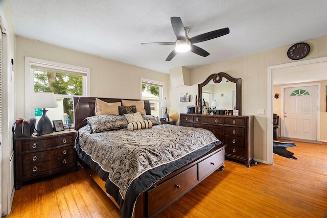 bedroom with ceiling fan, multiple windows, and light wood-type flooring