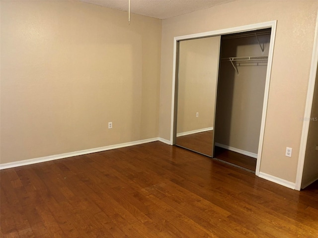 unfurnished bedroom with a closet and hardwood / wood-style floors