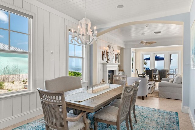 dining room with ceiling fan with notable chandelier, wooden ceiling, and light tile patterned flooring