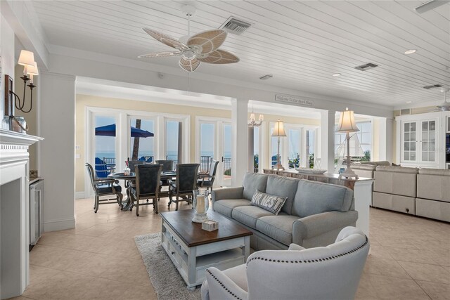 tiled living room with a water view, ceiling fan with notable chandelier, and wooden ceiling