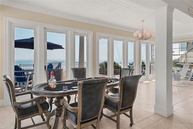 tiled dining space with a water view, wood ceiling, a wealth of natural light, and an inviting chandelier