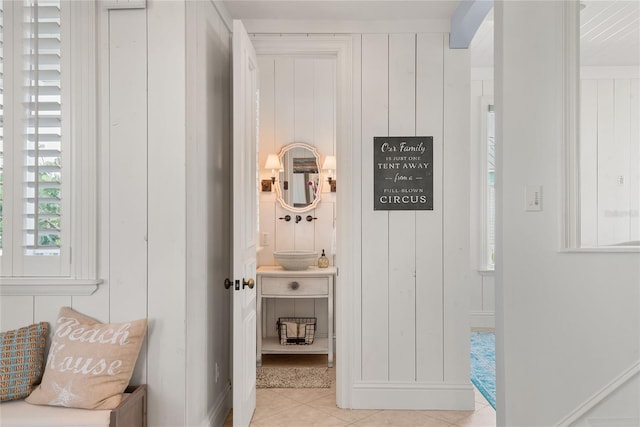 interior space with wood walls and light tile patterned flooring