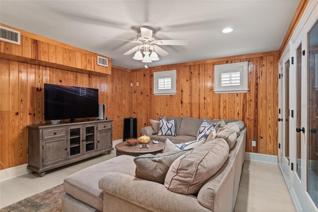 living room with french doors, wood walls, and ceiling fan