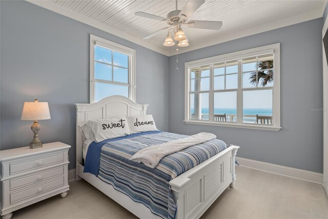 bedroom with light wood-type flooring, multiple windows, a water view, and ceiling fan