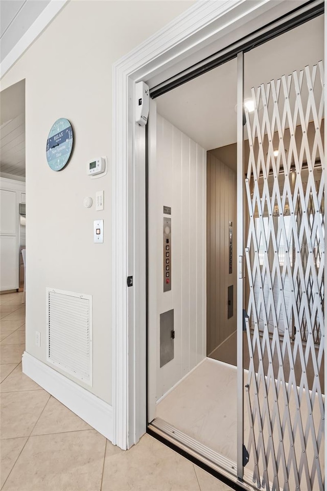 bathroom featuring elevator and tile patterned floors