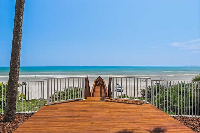 deck featuring a beach view and a water view