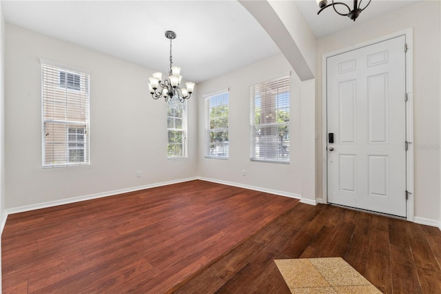 foyer entrance with a notable chandelier and dark hardwood / wood-style flooring