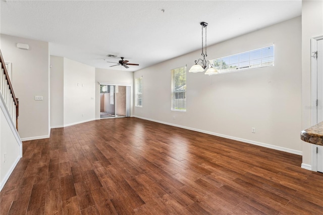 unfurnished living room featuring ceiling fan with notable chandelier and hardwood / wood-style floors