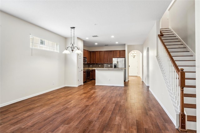 unfurnished living room featuring dark hardwood / wood-style flooring and a chandelier