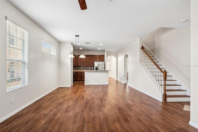 unfurnished living room with dark hardwood / wood-style floors and a healthy amount of sunlight