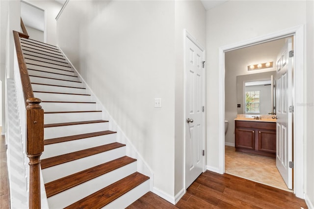 staircase with sink and wood-type flooring