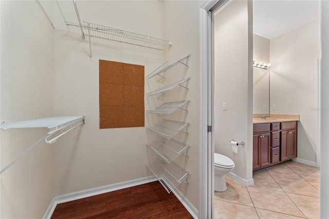 spacious closet with light wood-type flooring and sink