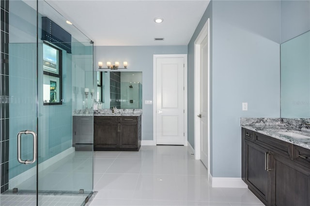 bathroom featuring walk in shower, dual vanity, and tile patterned floors