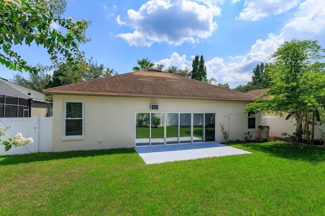 back of property with a yard and a patio