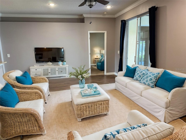 living room featuring wood-type flooring, a textured ceiling, ceiling fan, and ornamental molding