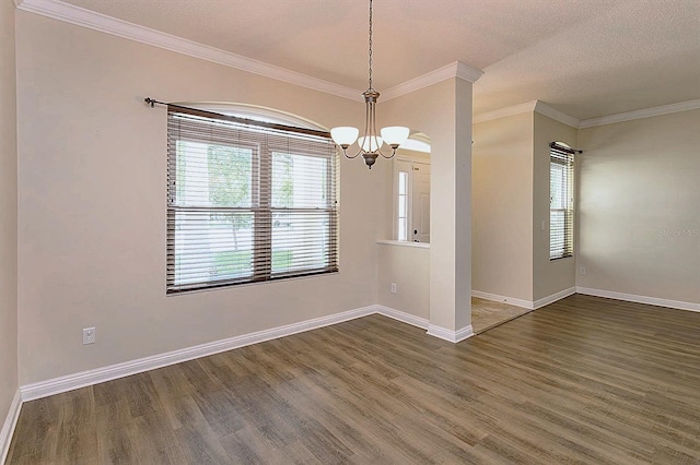 unfurnished room with a textured ceiling, crown molding, and dark wood-type flooring