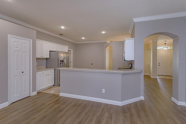 kitchen featuring white cabinets, light wood-type flooring, and ornamental molding