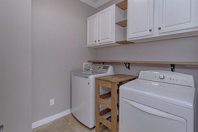 laundry area with crown molding, light tile patterned floors, cabinets, and independent washer and dryer