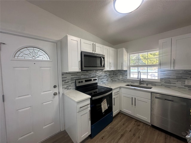 kitchen with sink, white cabinetry, stainless steel appliances, and tasteful backsplash