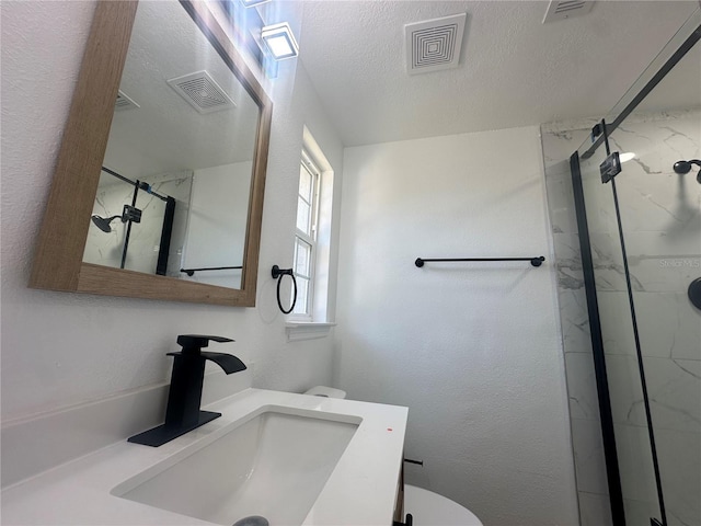 bathroom with vanity, a textured ceiling, and walk in shower