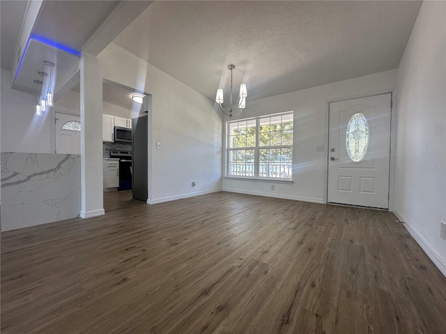 entryway with a notable chandelier and dark wood-type flooring