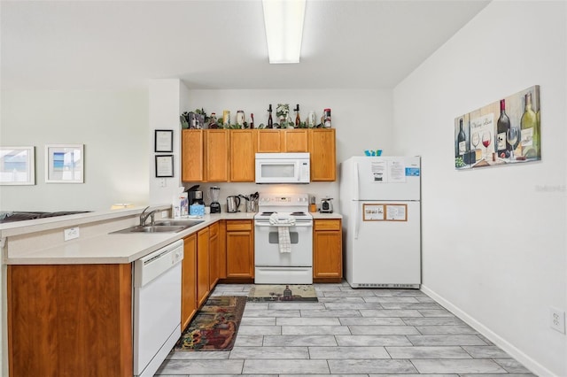 kitchen with kitchen peninsula, sink, and white appliances