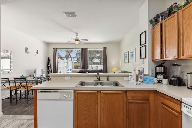 kitchen with sink, light hardwood / wood-style flooring, white dishwasher, and a wealth of natural light