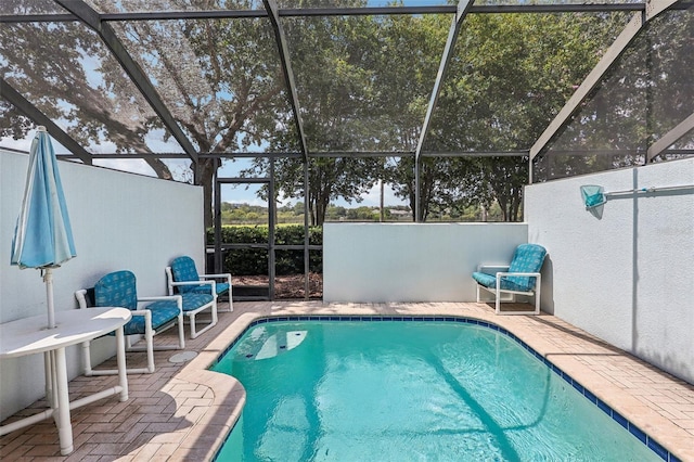 view of swimming pool with glass enclosure and a patio area