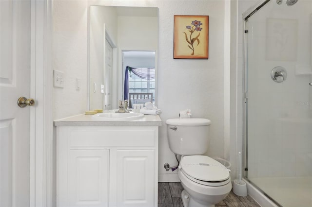 bathroom with walk in shower, hardwood / wood-style flooring, vanity, and toilet