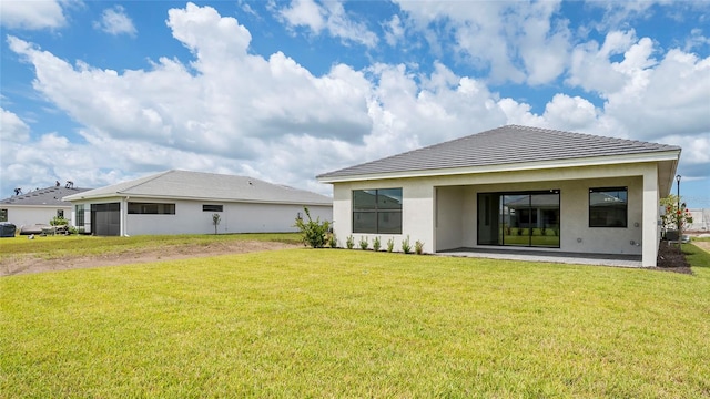 back of property with a lawn and a patio