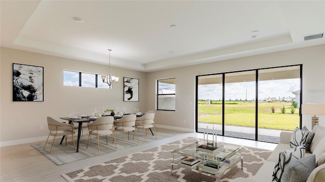 4845 Carova Way, Lakewood Ranch, FL 34211 - dining space with a tray ceiling, healthy amount of natural light, a chandelier, and baseboards