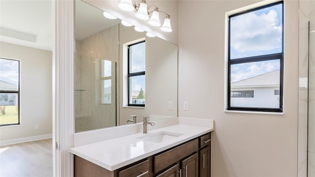 bathroom featuring hardwood / wood-style floors, vanity, and a tile shower