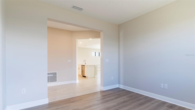 empty room with hardwood / wood-style floors and sink