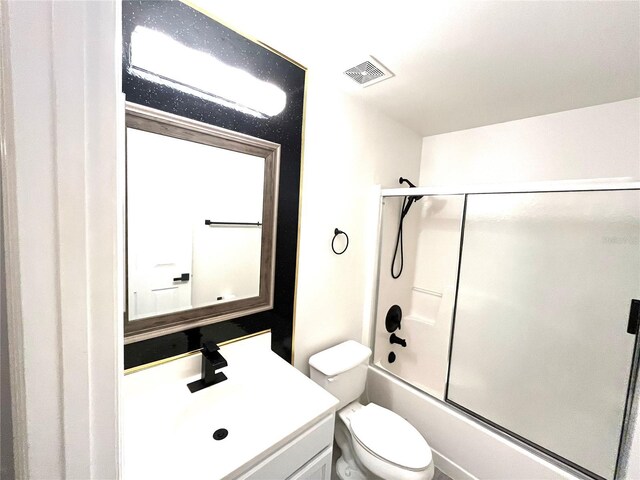 full bathroom featuring bath / shower combo with glass door, toilet, and vanity