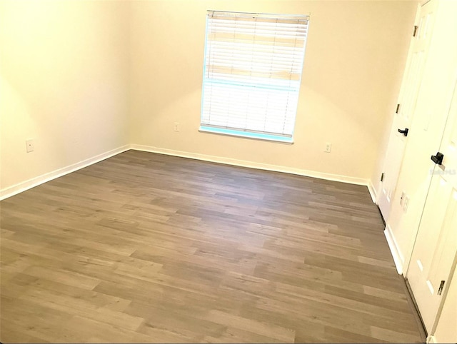 unfurnished room featuring baseboards and wood finished floors