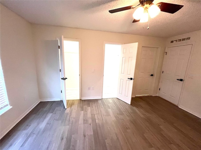 unfurnished bedroom featuring ceiling fan, hardwood / wood-style flooring, and a textured ceiling