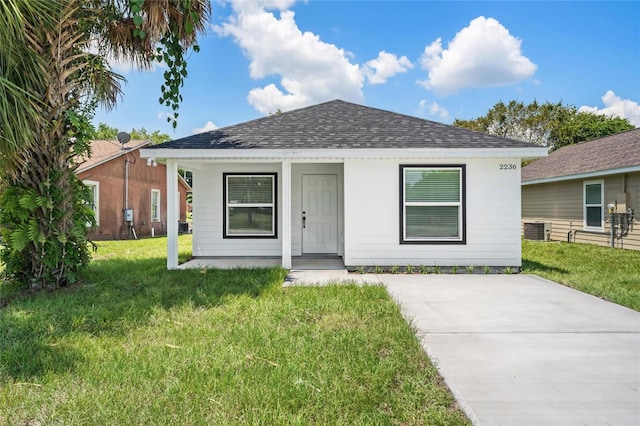 view of front of property featuring a front yard and cooling unit