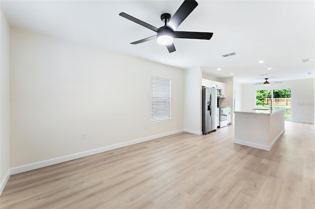 unfurnished living room featuring ceiling fan, light hardwood / wood-style flooring, and sink