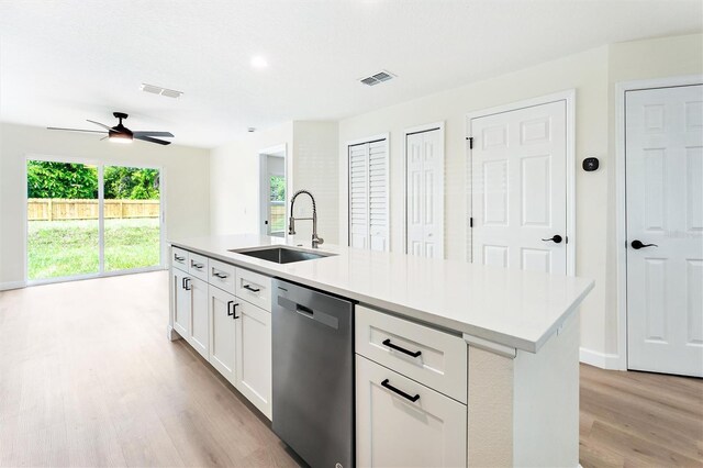 kitchen with ceiling fan, dishwasher, a center island with sink, light wood-type flooring, and sink