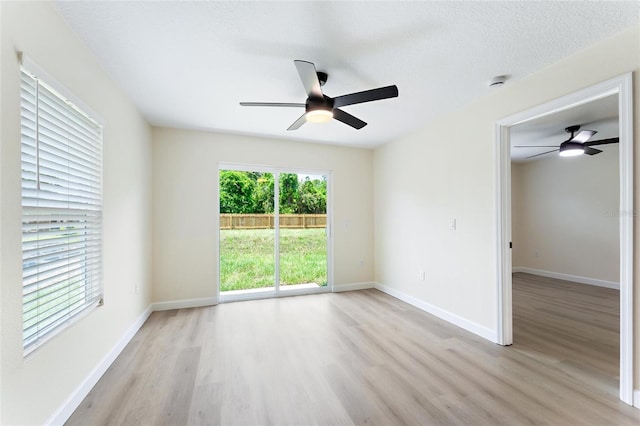spare room with ceiling fan, light hardwood / wood-style flooring, and a textured ceiling