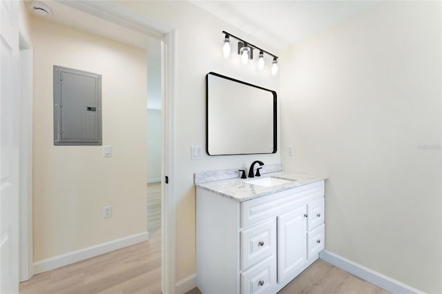 bathroom with hardwood / wood-style flooring, vanity, and electric panel