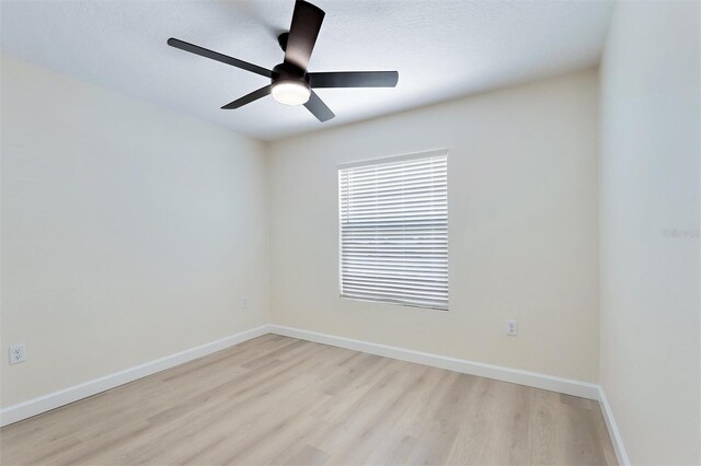 empty room with ceiling fan and light hardwood / wood-style floors