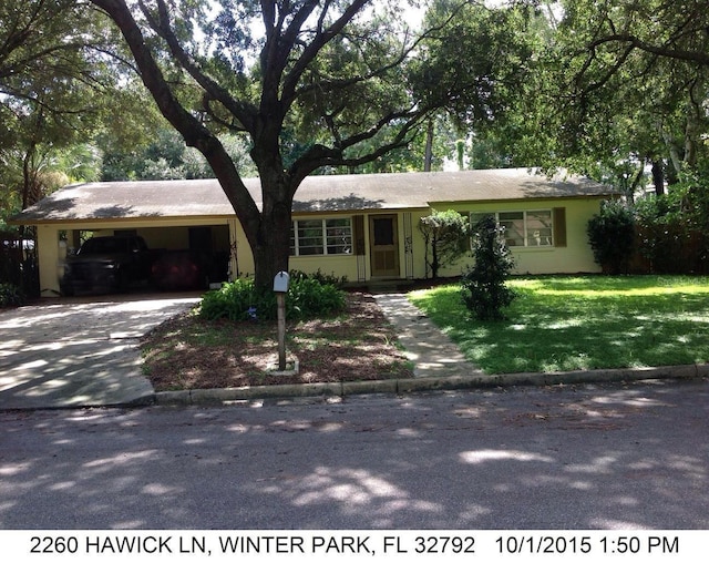 ranch-style house featuring a front lawn and a carport