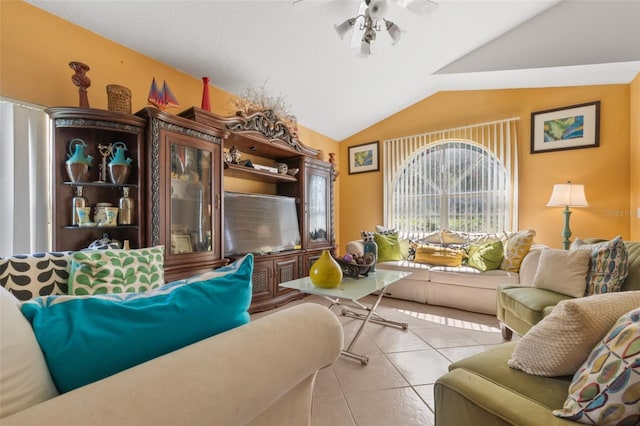 tiled living room with ceiling fan and vaulted ceiling