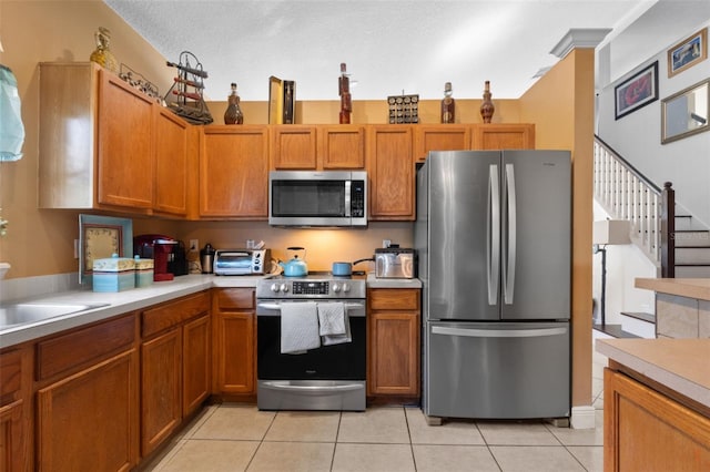 kitchen with light tile patterned flooring and appliances with stainless steel finishes