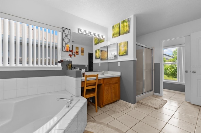 bathroom featuring a textured ceiling, shower with separate bathtub, vanity, and tile patterned floors