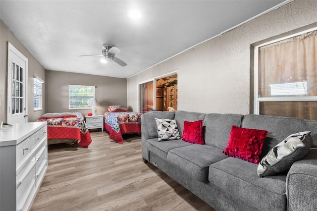 living room with ceiling fan and light hardwood / wood-style flooring