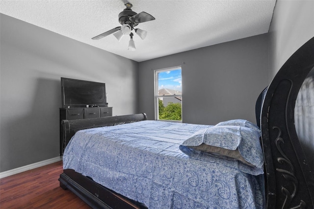 bedroom with ceiling fan, wood-type flooring, and a textured ceiling