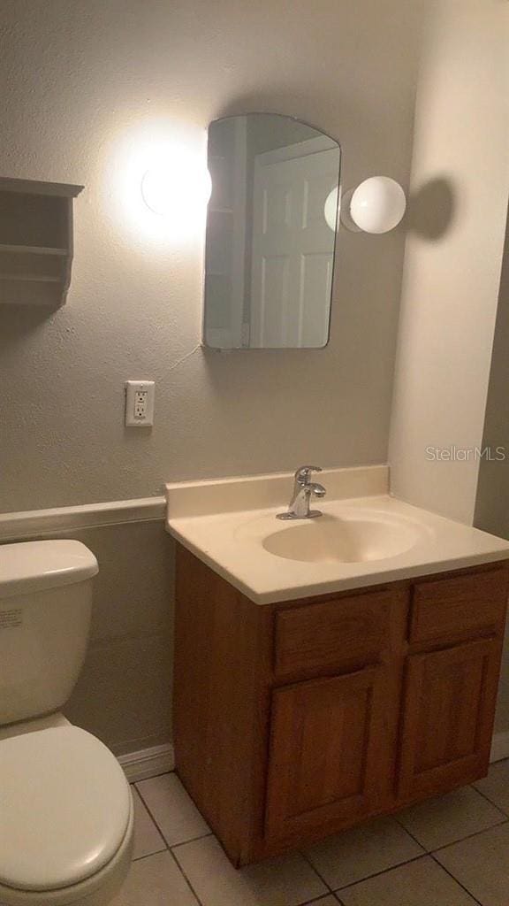 bathroom featuring vanity, toilet, and tile patterned flooring